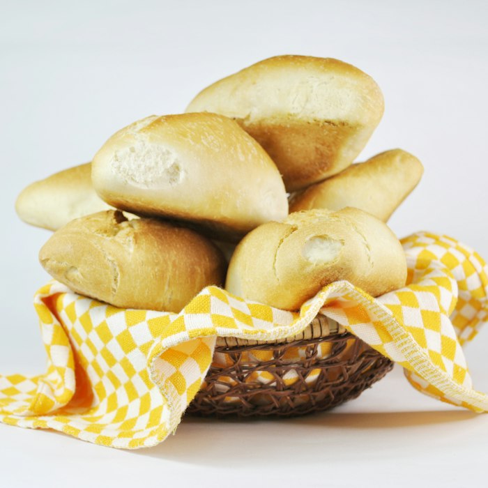 Pães franceses numa cesta com pano xadrez